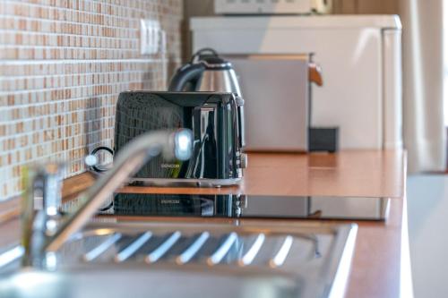 a kitchen counter with a coffee pot sitting on a stove at Sekli Apartman in Balatonlelle