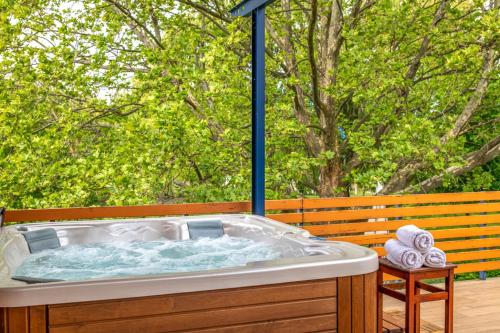 a jacuzzi tub with towels on a bench at Sekli Apartman in Balatonlelle