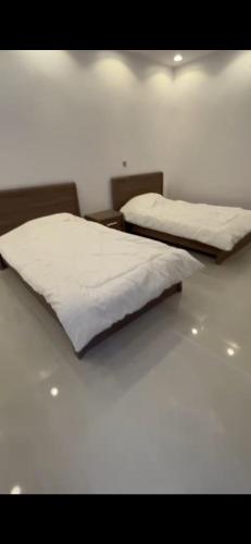 2 Betten nebeneinander in einem Zimmer in der Unterkunft الفهد in Mogayra