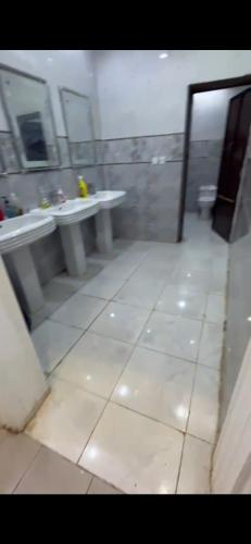 a bathroom with two sinks and a toilet in a room at الفهد in Mogayra