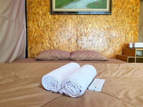 un letto con due asciugamani sopra di Buana Glamping a Pengalongan