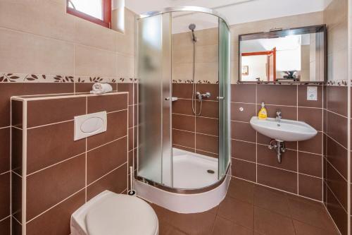 a bathroom with a shower and a toilet and a sink at Sekli Apartman in Balatonlelle