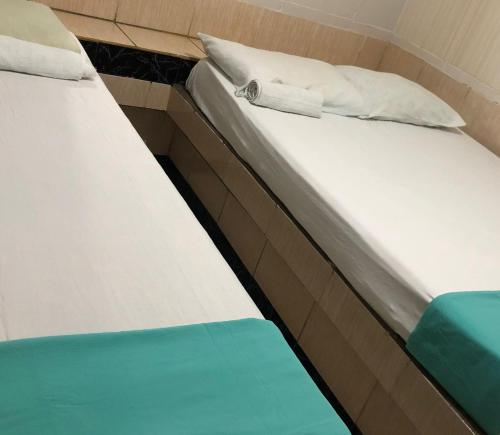 un par de camas en una habitación compartida en Pousada Aldo, en Delmiro Gouveia
