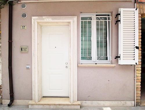 eine weiße Tür und ein Fenster auf ein Haus in der Unterkunft Casa Vacanze del Vicario in San Benedetto del Tronto