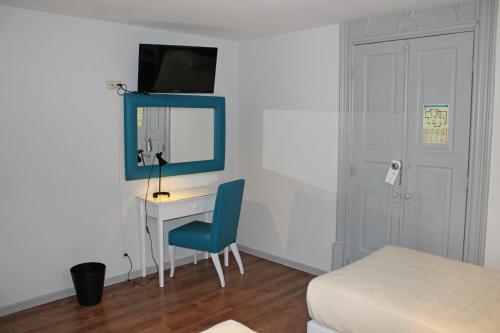 a room with a desk with a blue chair and a mirror at Hotel Porto Nobre in Porto