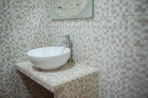 a bathroom with a white bowl sink on a counter at Bungalow Geringsing in Candidasa