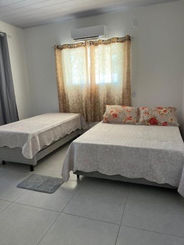 巴拉德卡瑪拉圖巴的住宿－Fdl espaço gourmet，一间卧室设有两张床和窗户。