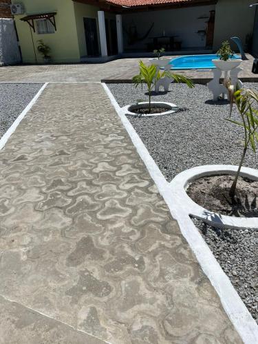 uma passagem de pedra com duas plantas e uma piscina em Fdl espaço gourmet em Barra de Camaratuba