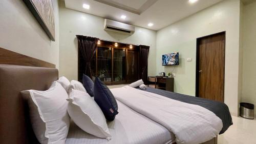 a bedroom with a large white bed with pillows at VARDHAN CORPORATE STAY in Pune