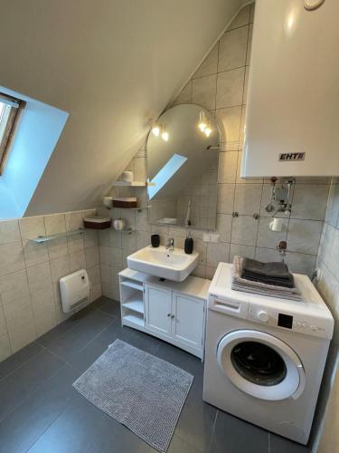 a bathroom with a washing machine and a sink at BullsLiving Seeapartment 5 in Velden am Wörthersee