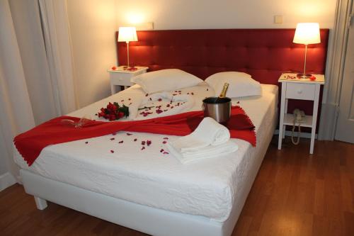 a bedroom with a large bed with red and white sheets at Hotel Porto Nobre in Porto