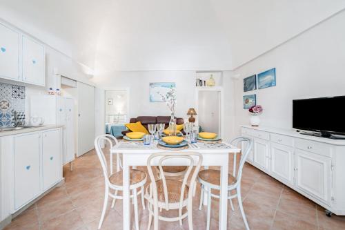 a kitchen and dining room with a white table and chairs at Vico di Ostuni Apartments by Rentbeat in Ostuni