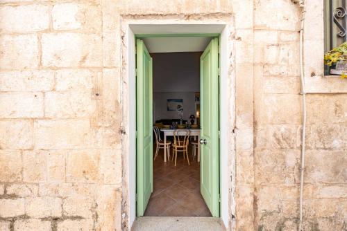 an open door into a dining room with a table at Vico di Ostuni Apartments by Rentbeat in Ostuni