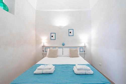 a bedroom with a bed with two towels on it at Vico di Ostuni Apartments by Rentbeat in Ostuni