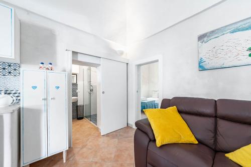 a living room with a brown couch and a bathroom at Vico di Ostuni Apartments by Rentbeat in Ostuni