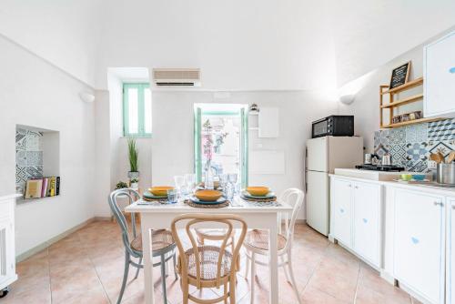 a kitchen with a white table and chairs at Vico di Ostuni Apartments by Rentbeat in Ostuni
