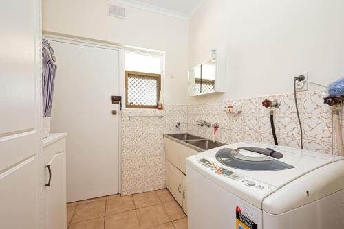 a kitchen with a sink and a washing machine at Vintage Charm in Vale Park in Broadview