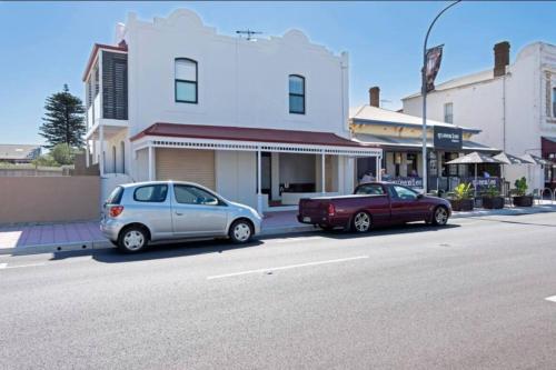 two cars parked on the side of a street at Lovely Beachside Largs Bay unit - free wine in Largs