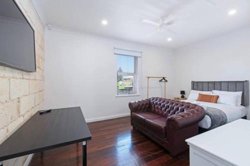 a living room with a couch and a bed at Lovely Beachside Largs Bay unit - free wine in Largs