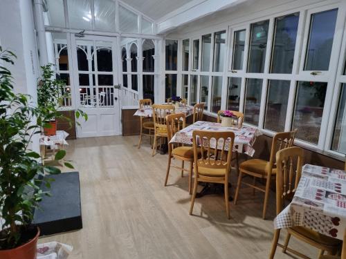 a dining room with tables and chairs and windows at The Monkey Puzzle in Bunclody