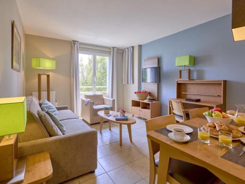 a living room with a couch and a table at Apartment Reine Marine- T2 SUD by Interhome in Saint Malo