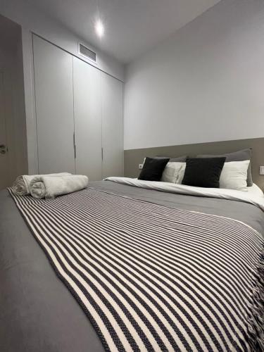uma cama grande com um cobertor listrado preto e branco em The Room Gotico em Barcelona