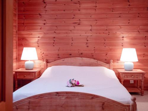 Un dormitorio con dos lámparas y una cama con flores. en Apartment Ambassadeur by Interhome, en Villars-sur-Ollon