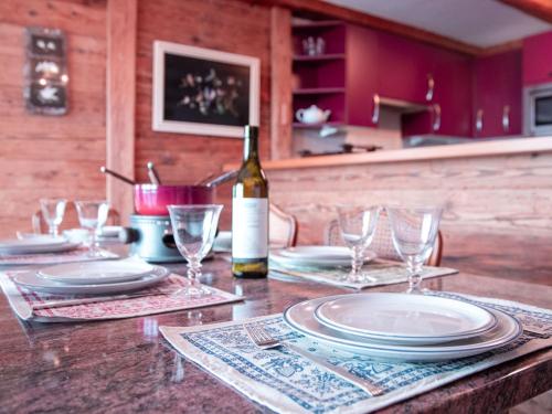 a table with plates and glasses and a bottle of wine at Apartment Ambassadeur 1 by Interhome in Villars-sur-Ollon