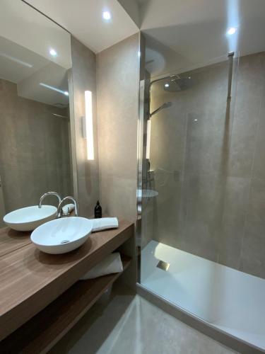 a bathroom with two sinks and a shower at Le Renaissance in Mont-de-Marsan