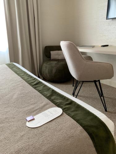 a hotel room with a bed and a chair at Le Renaissance in Mont-de-Marsan
