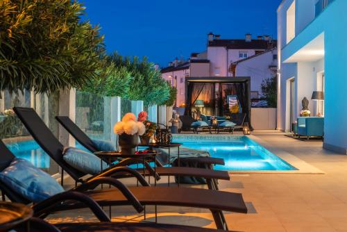 a patio with chairs and a swimming pool at Monvidal Residence - Adults Only in Pula