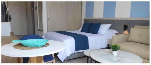 1 dormitorio con 1 cama, 2 mesas y 1 sofá en ApartaSuite 932 en Porto Horizonte SANTA MARTA, en Santa Marta
