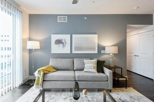 ein Wohnzimmer mit einem grauen Sofa in einem Zimmer in der Unterkunft Landing at The Monroe - 2 Bedrooms in Montopolis in Austin