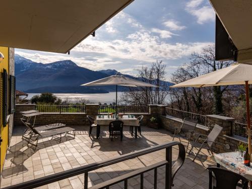 a patio with a table and chairs and an umbrella at Apartment Raggio di Sole Apartment A by Interhome in Consiglio di Rumo