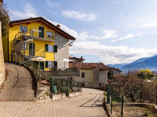 a yellow house on the side of a road at Apartment Raggio di Sole Apartment A by Interhome in Consiglio di Rumo