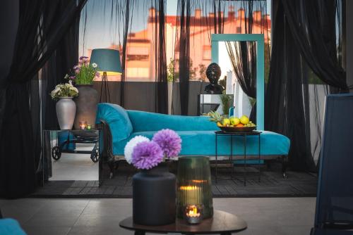 a living room with a blue couch and a mirror at Monvidal by Bura Hotels - Adults Only in Pula