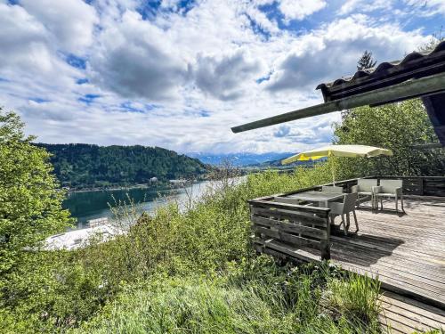 a wooden deck with a table and an umbrella at Holiday Home Häuschen am Waldrand by Interhome in Annenheim