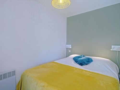 une chambre avec un lit avec une couverture jaune et blanche dans l'établissement Apartment Les Voiles de La Baule by Interhome, au Pouliguen