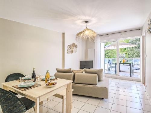 ein Wohnzimmer mit einem Sofa und einem Tisch in der Unterkunft Apartment Les Voiles de La Baule by Interhome in Le Pouliguen