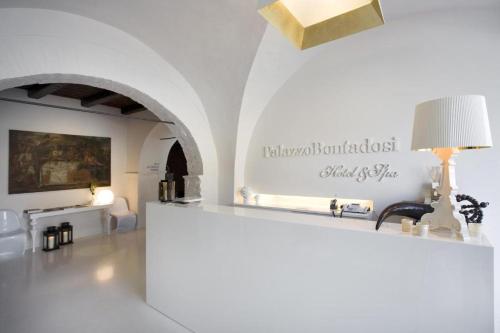 a white room with a table and a lamp at Mirabilia Retreats - Palazzo Bontadosi in Montefalco
