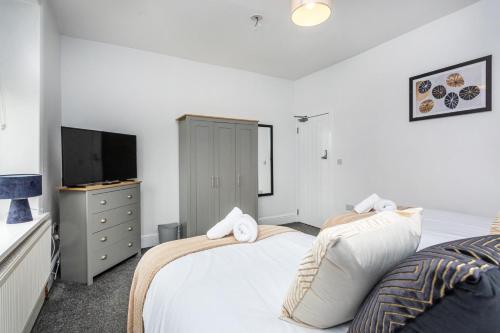 um quarto com 2 camas e uma televisão de ecrã plano em Fabulous 3 bed house in Burnley em Brierfield