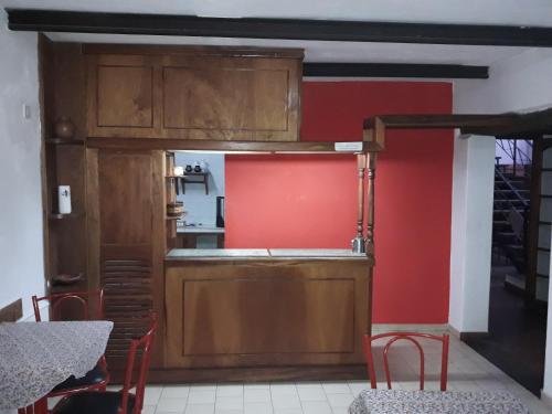 a kitchen with red walls and a red wall at La Posada del Rey in Mina Clavero