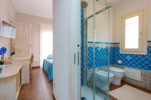 a bathroom with a shower and a toilet and a sink at La rosa dei venti in Villasimius