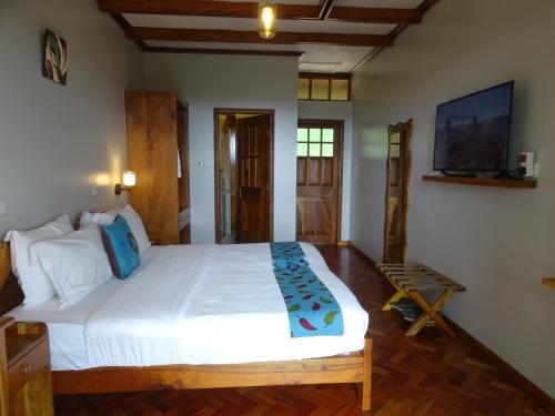 a bedroom with a large white bed in a room at Le Pristine Wellness and Healing Hotel in Nyeri