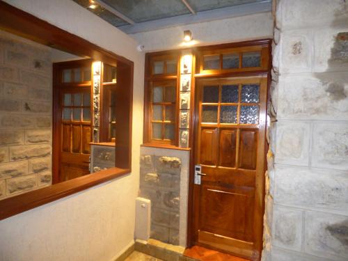 a hallway with two wooden doors in a building at Le Pristine Wellness and Healing Hotel in Nyeri