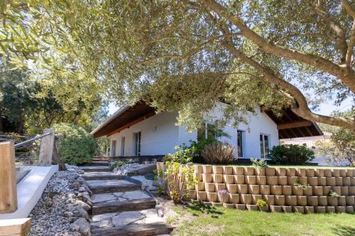 a house with a retaining wall next to a yard at Villa Blanche - Moliets Et Maa in Moliets-et-Maa