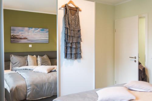 two images of a bedroom with a bed and a door at Birkenstraße 6 Haus II Whg2 in Zingst