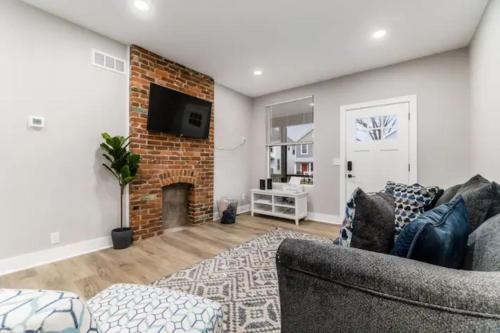 a living room with a couch and a brick fireplace at 2 homes side by side downtown with fenced yard and hot tub in Columbus