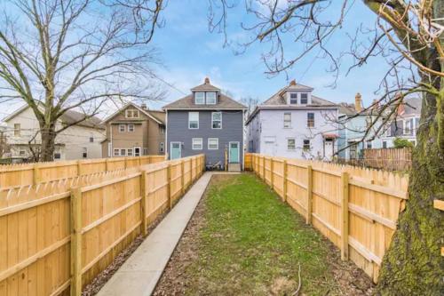 a wooden fence in front of a row of houses at 2 homes side by side downtown with fenced yard and hot tub in Columbus