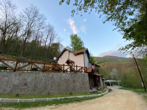 una casa en la parte superior de una pared de piedra en Kuca za odmor ,,Balkan” en Crni Vrh